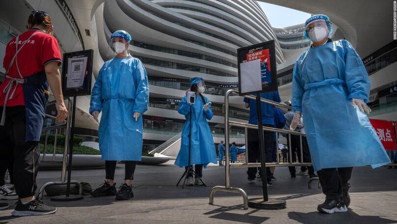 Các nhân viên y tế mặc quần áo bảo hộ tại lối vào khu thử nghiệm Covid-19 tại một khu phức hợp mua sắm ở Bắc Kinh.