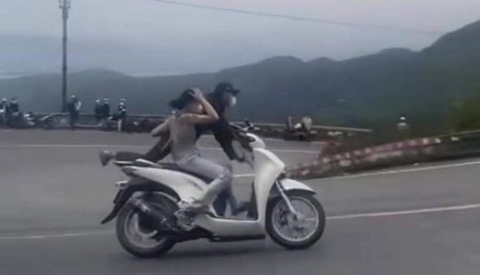 Cặp vợ chồng tuổi teen chạy xe máy diễn xiếc trên đèo Hải Vân. Ảnh từ clip