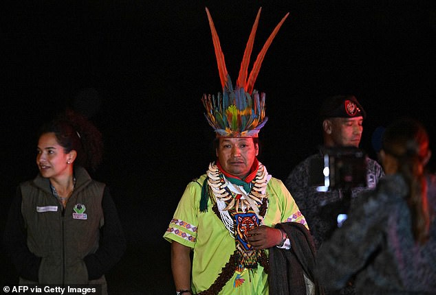 Một người đàn ông bản địa tham gia cùng quân đội trong cuộc tìm kiếm bốn đứa trẻ đứng cạnh máy bay khi bọn trẻ đến nơi. (Ảnh: dailymail.co.uk)