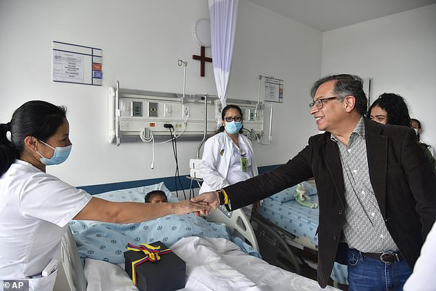 Tổng thống Gustavo Petro bắt tay một y tá đang chăm sóc cho một trong bốn đứa trẻ bản địa sống sót sau vụ tai nạn máy bay ở Amazon. (Ảnh: dailymail.co.uk)
