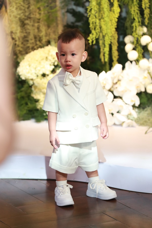 Nhóc tỳ bảnh bao trong bộ vest trắng cùng tông với bố mẹ.
