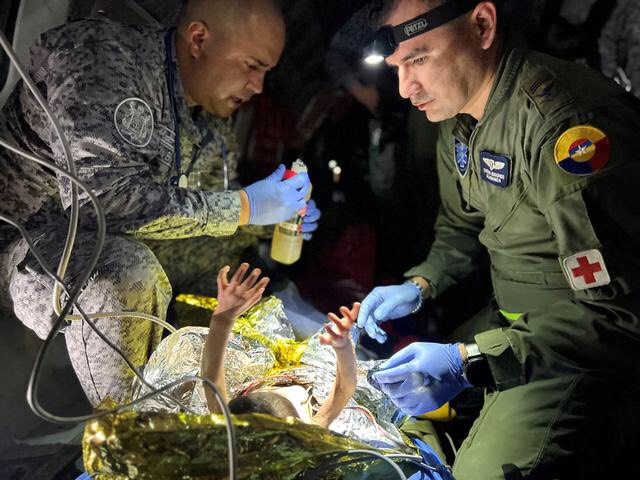 Các binh sĩ của Lực lượng Không quân Colombia chăm sóc cho những đứa trẻ sống sót sau vụ tai nạn máy bay Cessna 206.