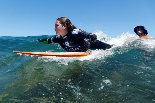 Sarah Almagro, 23 tuổi, tập lướt sóng với huấn luyện viên Javier Donoso. (Ảnh: REUTERS/Borja Suárez)