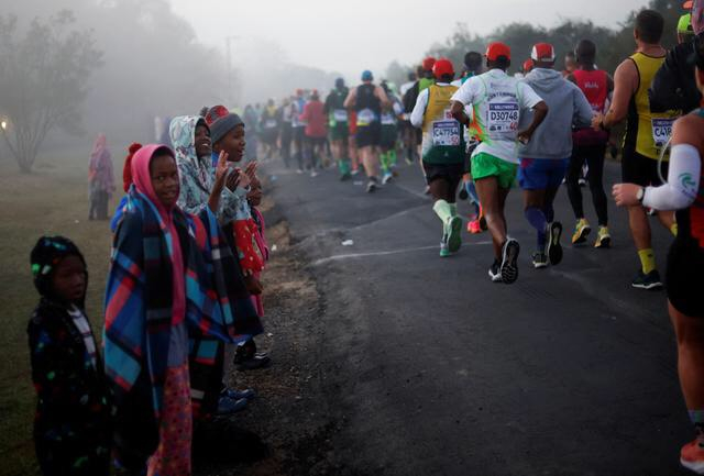 Người dân cổ vũ hai bên đường khi các vận động viên tranh tài trong cuộc thi Marathon Đồng đội đi qua Ashburton, Nam Phi. (Ảnh: REUTERS/Phường Rogan)