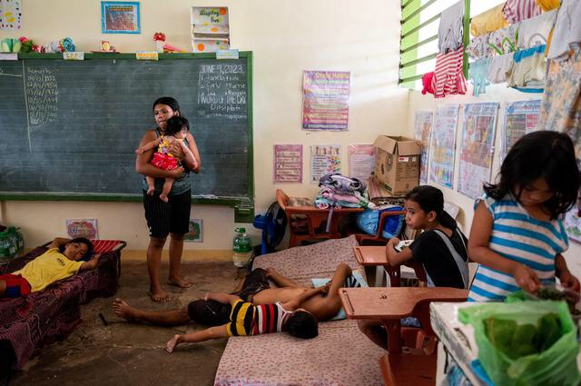 Chị Elena Rosales, 23 tuổi, bế con gái trong lớp học được chuyển đổi thành nơi sơ tán sau khi mức độ cảnh báo của Núi lửa Mayon tăng cao, ở Daraga, tỉnh Albay, Philippines. (Ảnh: REUTERS/Lisa Marie David)