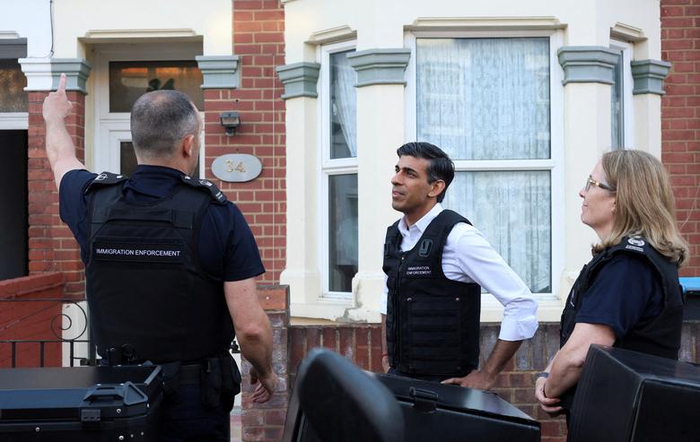 Thủ tướng Anh Rishi Sunak theo dõi một cuộc đột kích nhập cư ở Tây Bắc London, Anh. (Ảnh: REUTERS/Susannah Ireland)