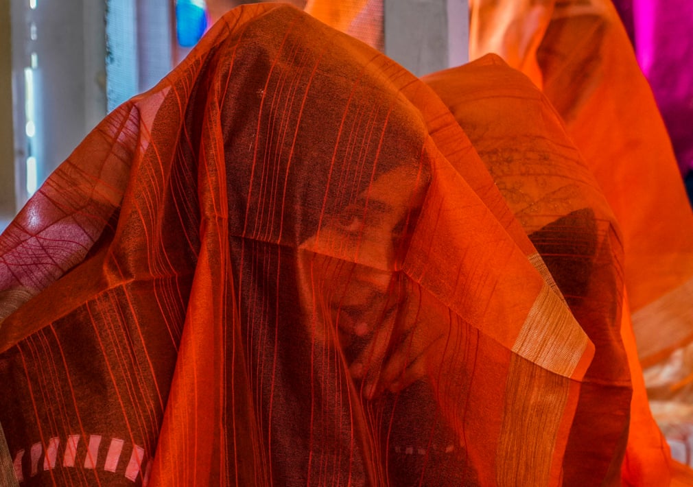 Một cô dâu Hồi giáo Kashmir e thẹn nhìn qua vải che mặt trong đám cưới tập thể tại Ấn Độ. (Ảnh: Mukhtar Khan/AP)