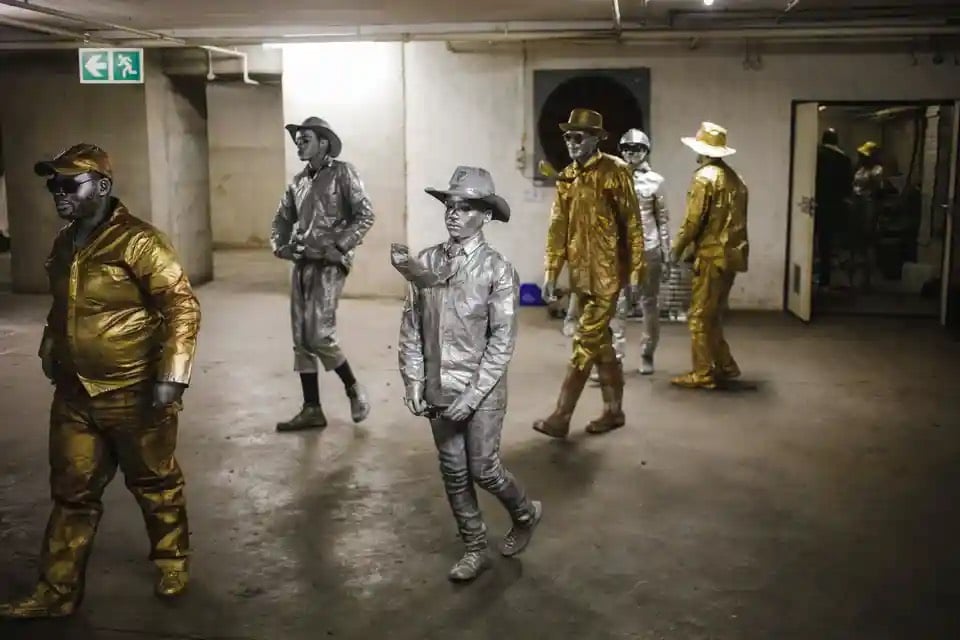 Các nghệ sĩ biểu diễn đường phố rời phòng chuẩn bị ở bãi đậu xe của một trung tâm mua sắm trước khi biểu diễn (Nam Phi). (Ảnh: Kim Ludbrook/EPA)