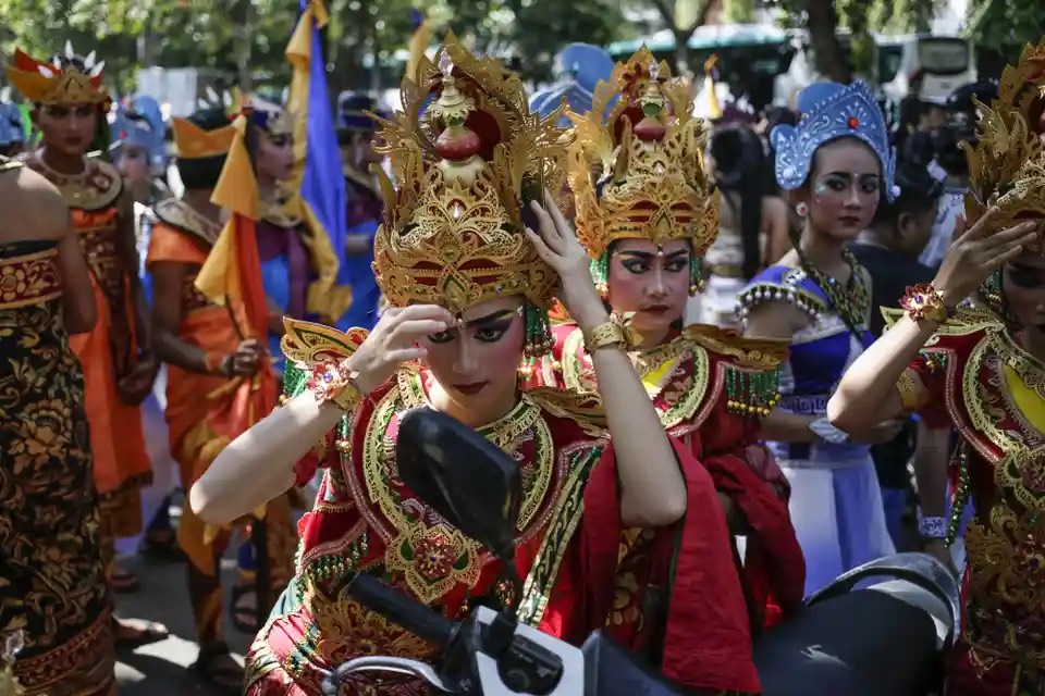 Một người tham gia lễ hội kiểm tra lại trang phục của mình trong gương xe máy trong cuộc diễu hành tại lễ hội nghệ thuật Bali (Indonesia). (Ảnh: Anadolu Agency/Getty Images)