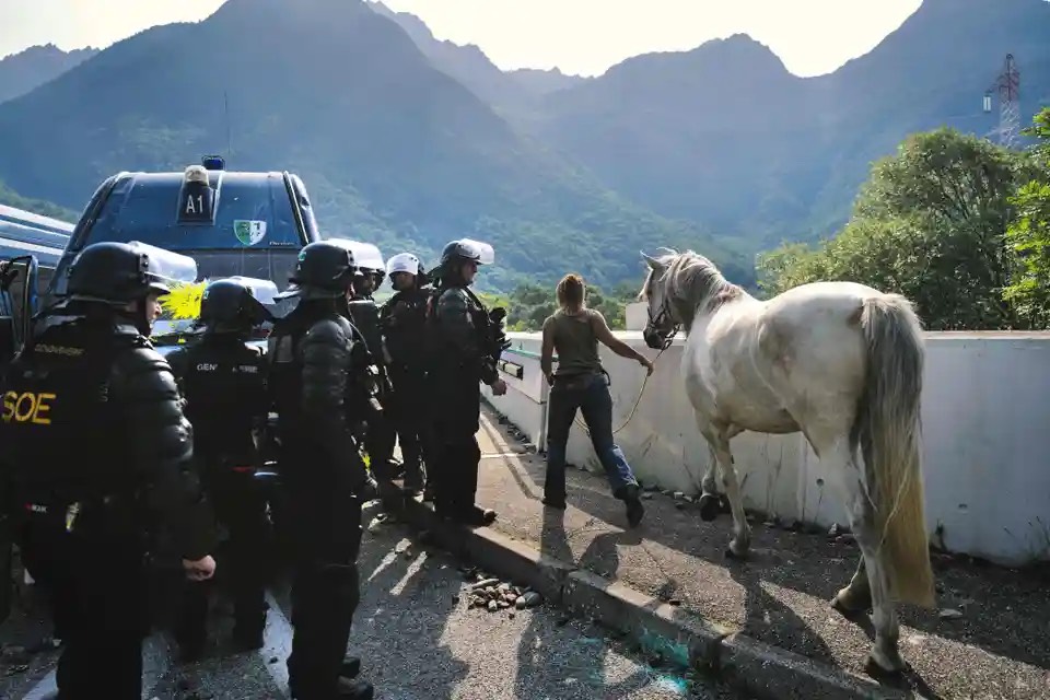 Cảnh sát Pháp cho phép một người phụ nữ và con ngựa của cô ấy đi qua trong cuộc biểu tình phản đối việc xây dựng tuyến đường sắt cao tốc giữa Lyon và Turin. (Ảnh: Olivier Chassignole/AFP/Getty Images)