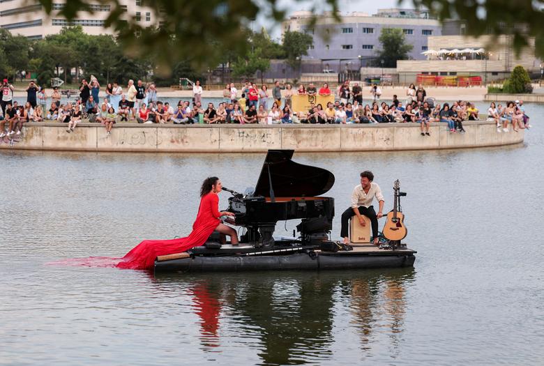 Nghệ sĩ dương cầm Violette Prevost biểu diễn một buổi hòa nhạc cổ điển trên bục nổi ở hồ Pradolongo, Tây Ban Nha. (Ảnh: REUTERS/Isabel Infantes)