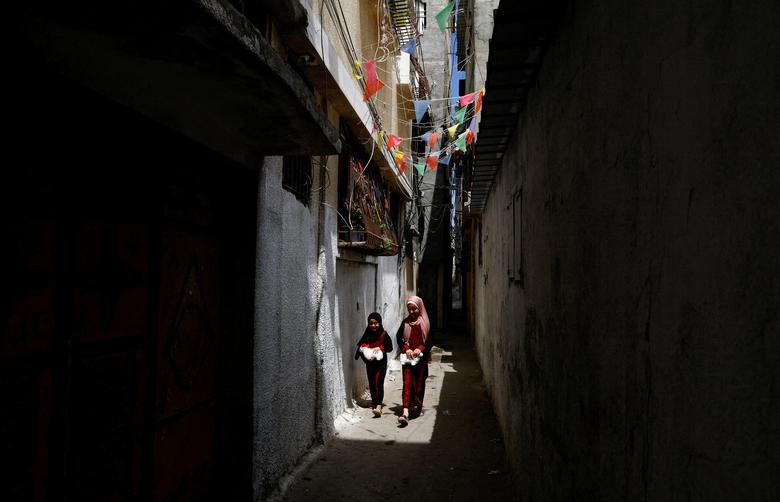 Các cô gái người tị nạn Palestine đi bộ tại trại tị nạn Al - Shati vào Ngày Tị nạn Thế giới, ở thành phố Gaza. (Ảnh: REUTERS/Mohammed Salem)