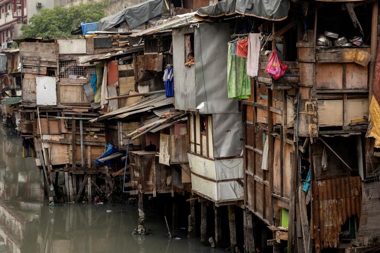 Một bé gái nhìn ra ngoài từ cửa sổ của một khu ổ chuột ở Manila, Philippines. (Ảnh :REUTERS/Eloisa López)