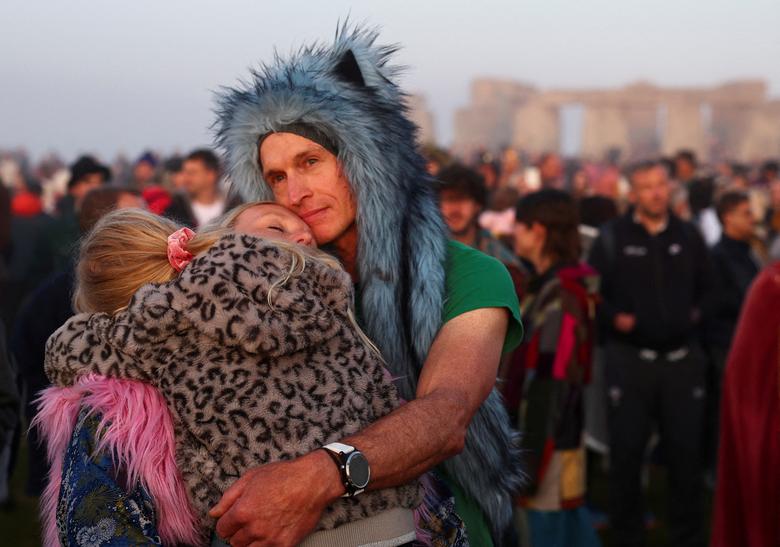 Một cặp đôi ôm nhau khi họ tham dự lễ kỷ niệm ngày hạ chí tại Stonehenge gần Amesbury, Anh. (Ảnh: REUTERS/Toby Melville)