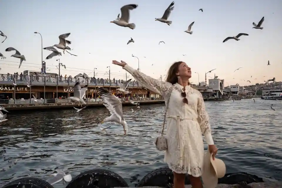 Một người phụ nữ chụp ảnh với mòng biển ở Thổ Nhĩ Kỳ. (Ảnh: Anadolu Agency/Getty Images)
