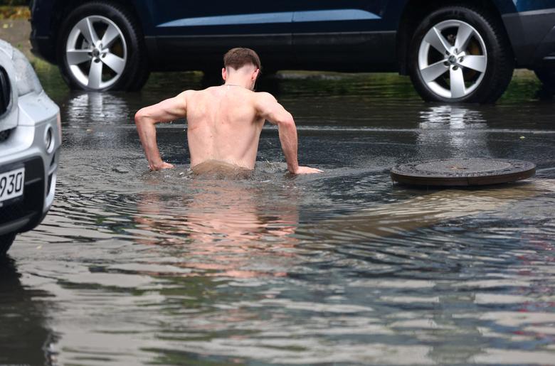 Một người nhảy xuống hố chứa đầy nước sau trận mưa lớn ở Berlin (Đức). (Ảnh: REUTERS/Fabrizio Bensch)
