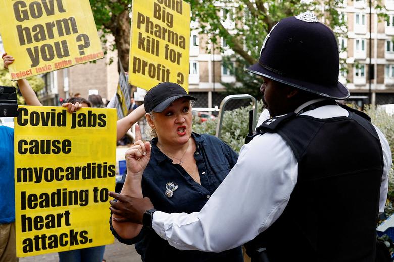 Một sĩ quan cảnh sát bắt giữ một người biểu tình chống vắc-xin bên ngoài Cuộc điều tra COVID-19, ở London (Anh). (Ảnh: REUTERS/Peter Nicholls)