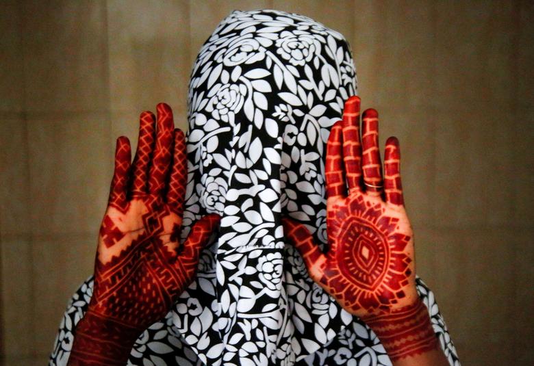 Một phụ nữ Hồi giáo khoe đôi tay có hình xăm henna một ngày trước lễ Eid al-Adha, ở Adjame (Abidjan, Bờ Biển Ngà). (Ảnh: REUTERS/Luc Gnago)