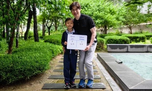 Bé Yoon Jae-ha (trái), cầm tấm bảng ghi tuổi quốc tế là 8 và tuổi Hàn Quốc là 9. (Ảnh: AFP)