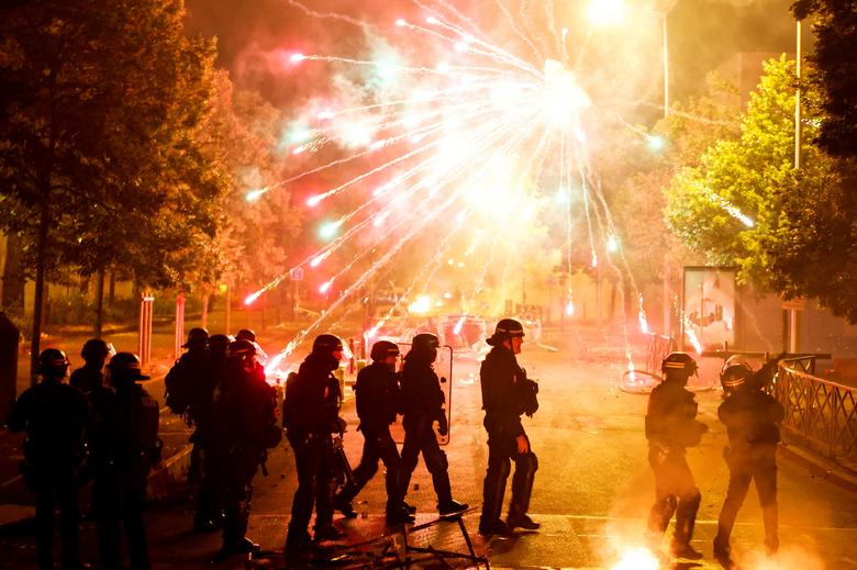 Cảnh sát Pháp đứng tại chỗ khi pháo hoa nổ trong cuộc đụng độ với thanh niên sau khi một thiếu niên 17 tuổi bị bắn chết bởi một sĩ quan cảnh sát. (Ảnh: REUTERS/Gonzalo Fuentes)