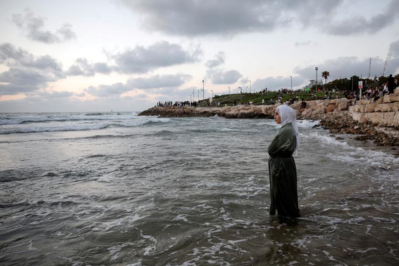Một phụ nữ Palestine đứng trên biển Địa Trung Hải trong chuyến thăm Tel Aviv trong kỳ nghỉ lễ Eid al-Adha của người Hồi giáo ở Tel Aviv (Israel). (Ảnh: REUTERS/Shir Torem)