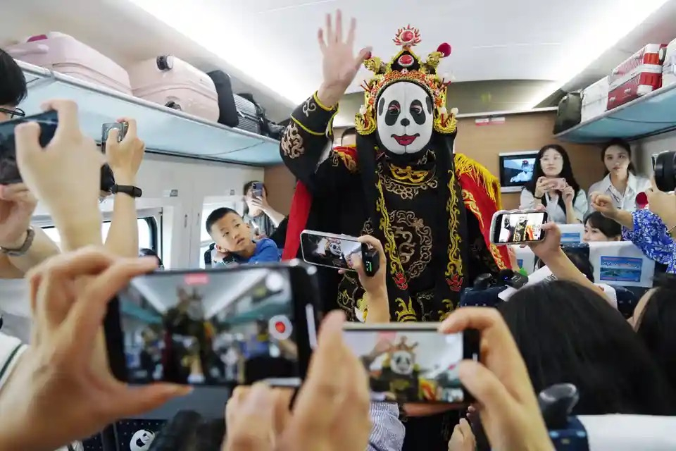 Hành khách thưởng thức màn biểu diễn trên tàu nhân dịp khai trương dịch vụ tàu cao tốc giữa Thành Đô và Hồng Kông (Trung Quốc). (Ảnh: Tân Hoa Xã/Shutterstock)