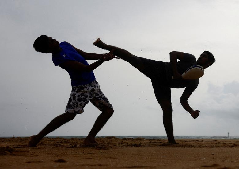 Hai người đàn ông biểu diễn võ thuật trên một bãi biển ở thị trấn ngoại ô Colombo (Sri Lanka). (Ảnh: REUTERS/Dinuka Liyanawatte)