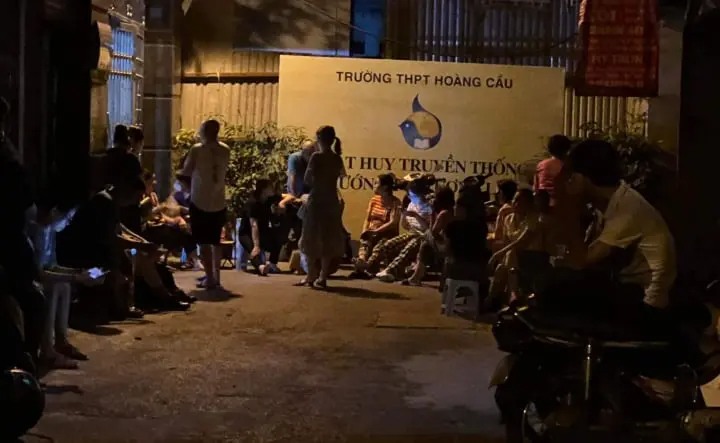 Nhiều phụ huynh vây kín cổng Trường THPT Hoàng Cầu trong đêm. (Ảnh Nhóm Đồng hành)
