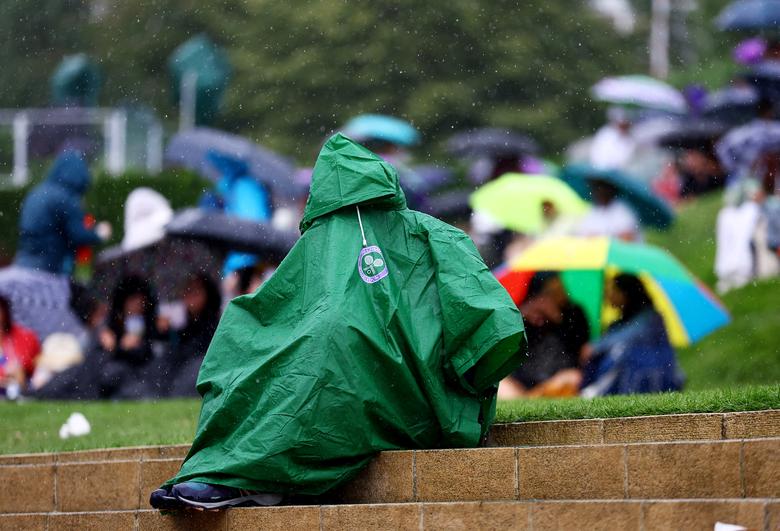 Một khán giả mặc áo mưa trên sân Wimbledon tại vòng đấu đầu tiên của trận đấu Wimbledon ở London (Anh). (Ảnh: REUTERS/Hannah Mckay)