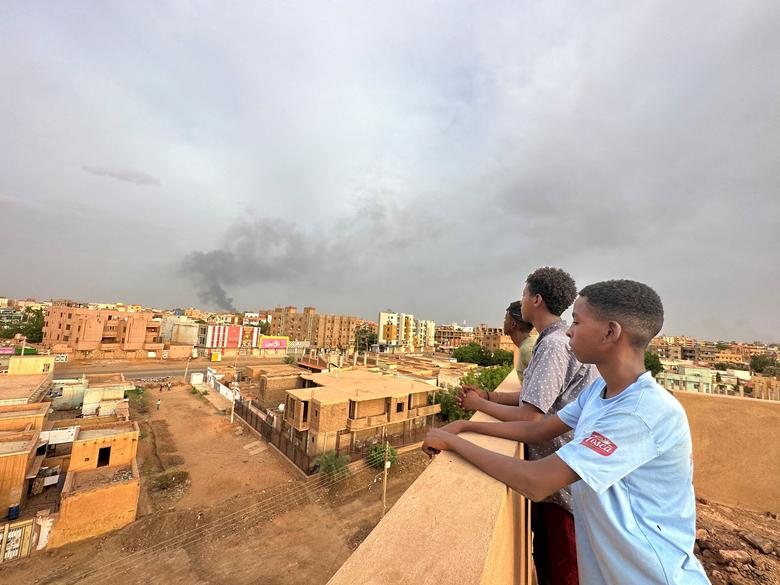 Người dân đứng nhìn khói bốc lên trong cuộc đụng độ giữa quân đội và Lực lượng hỗ trợ nhanh bán quân sự (RSF), ở Omdurman (Sudan). (Ảnh: REUTERS/Mostafa Saied)