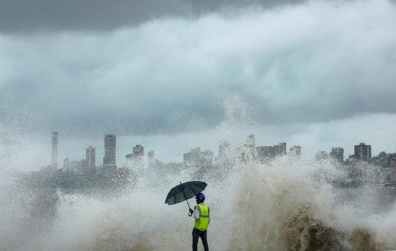 Một công nhân quan sát khi những con sóng xô vào công trường xây dựng đường ven biển khi thủy triều lên, ở Mumbai (Ấn Độ). (Ảnh: REUTERS/Francis Mascarenhas)
