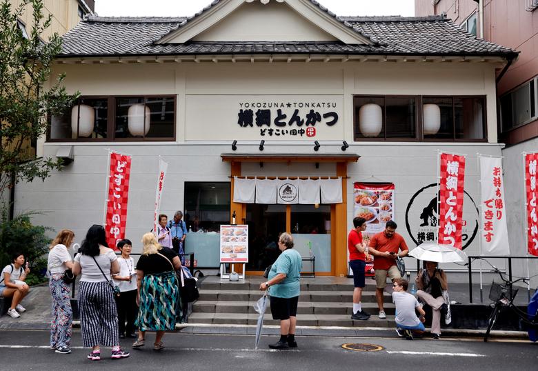 Khách du lịch từ nước ngoài chờ khai trương nhà hàng theo chủ đề đấu vật Yokozuna Tonkatsu Dosukoi Tanaka, ở Tokyo (Nhật Bản). (Ảnh: REUTERS/Issei Kato)