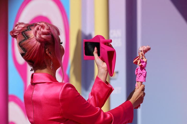 Một người hâm mộ chụp ảnh búp bê Barbie tại buổi ra mắt bộ phim 'Barbie' ở Los Angeles (California). (Ảnh: REUTERS/Mike Blake)