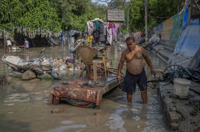 Ông Vinay Kumar Bhandari, 47 tuổi, dọn dẹp cửa hàng sau khi nước lũ rút ở New Delhi (Ấn Độ). (Ảnh: REUTERS/Adnan Abidi)