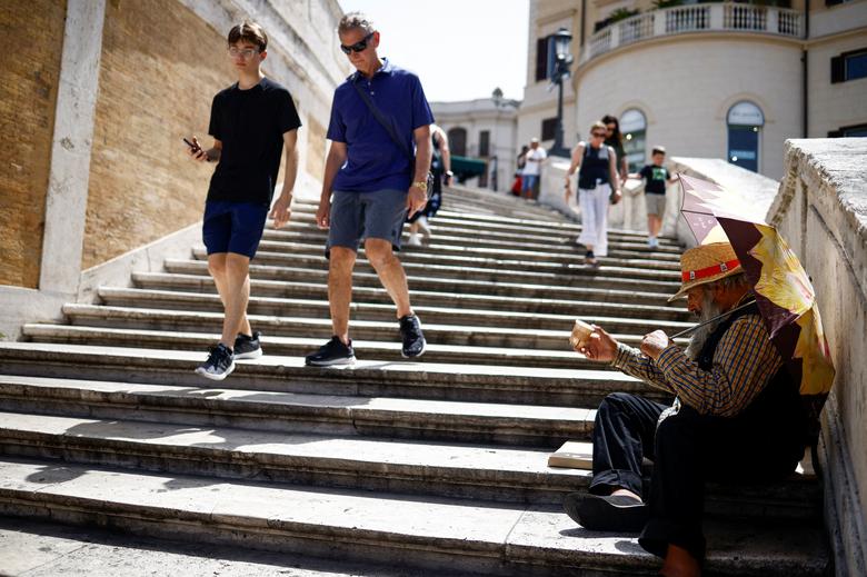 Người đàn ông ngồi ở 'Bậc thang Tây Ban Nha' (Rome, Ý) để tránh nắng. (Ảnh: REUTERS/Guglielmo Mangiapane)