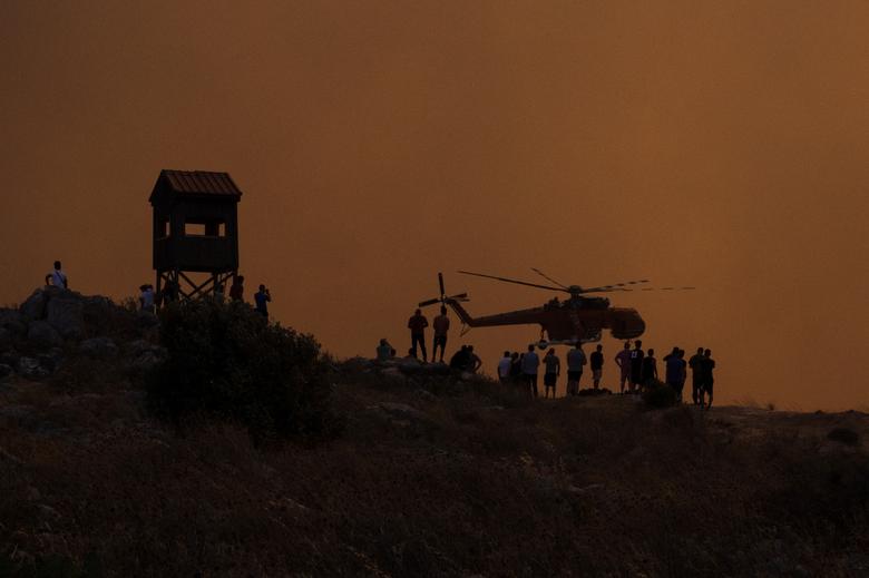 Một chiếc trực thăng chữa cháy bay bên cạnh đỉnh đồi ở Mandra (Hy Lạp). (Ảnh: REUTERS/Alkis Konstantinidis)