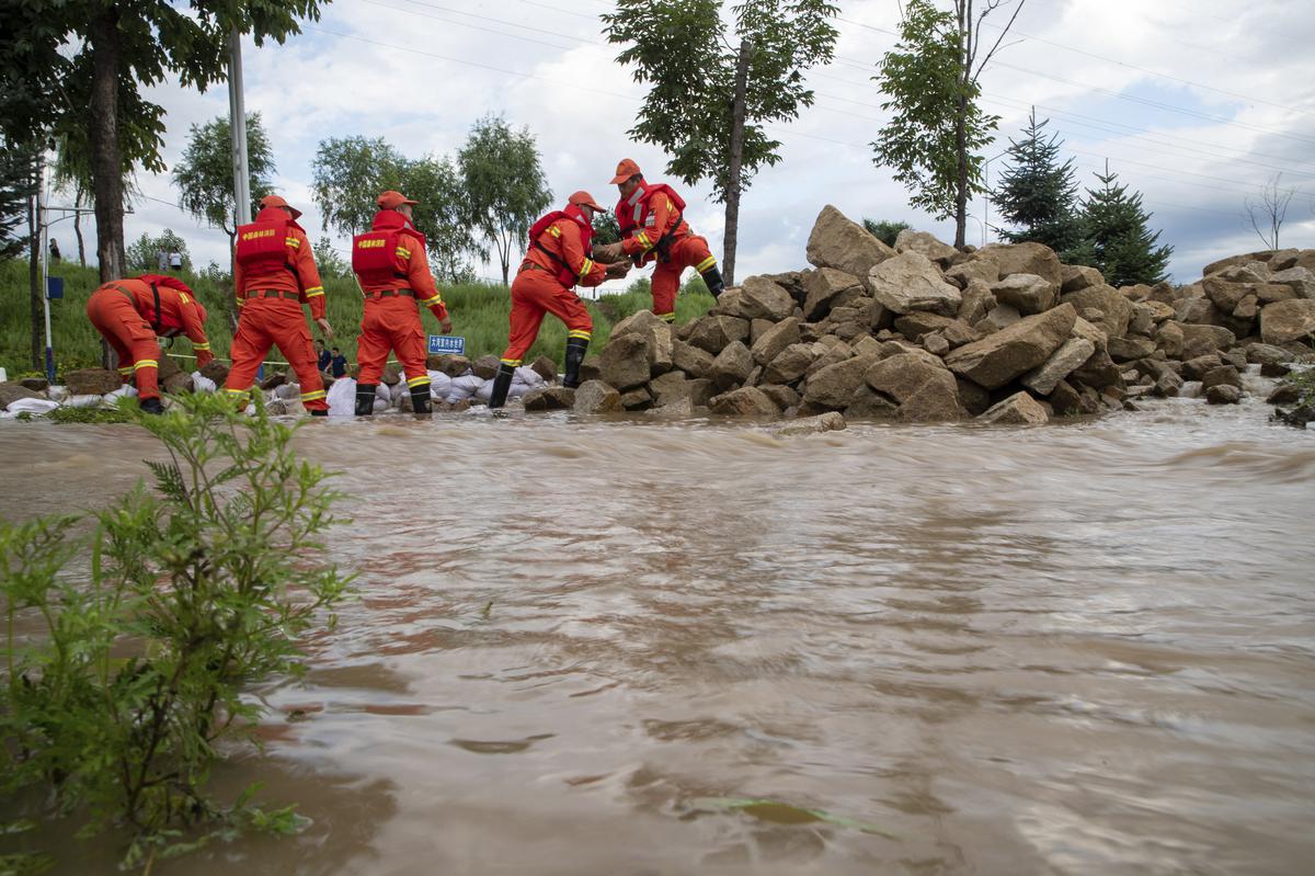 Lực lượng cứu hộ sử dụng đá để xây hàng rào ngăn nước lũ ở tỉnh Hắc Long Giang. (Ảnh: AP)