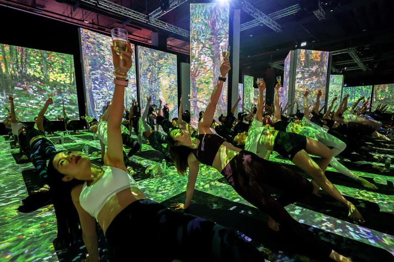 Những người đam mê yoga tập luyện tại triển lãm 'Van Gogh: The Immersive Experience' ở Bangkok (Thái Lan). (Ảnh: REUTERS/Athit Perawongmetha)