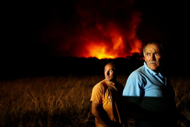 Người dân theo dõi đám cháy rừng ở Aljezur (Bồ Đào Nha). (Ảnh: REUTERS/Pedro Nunes)