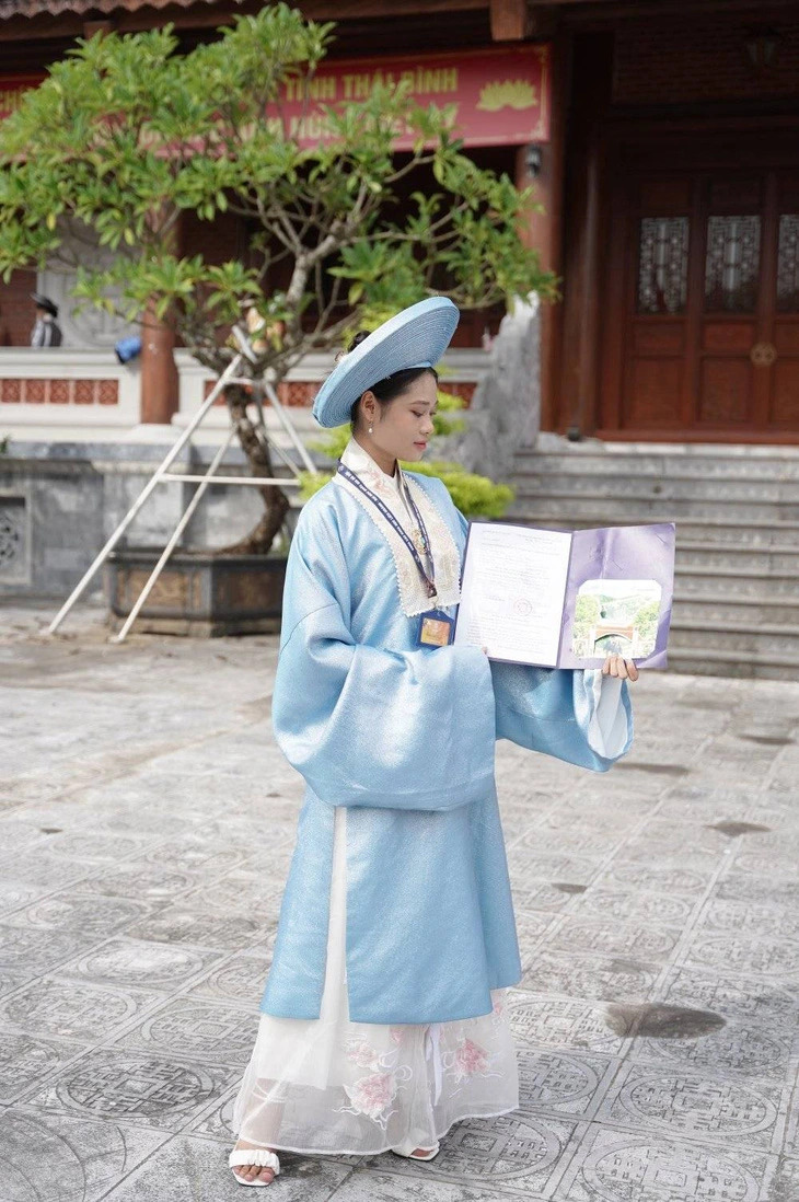 Một tân sinh viên mặc cổ phục thướt tha 'flex' cùng giấy báo trúng tuyển khoa Các khoa học học liên ngành, Đại học Quốc gia Hà Nội. (Ảnh: C.H.N.)