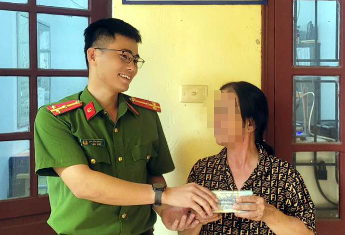 Thượng úy Lưu Văn Ngọc trao trả lại số tiền 115 triệu đồng cho bà H.T. T. (Ảnh: Báo Bắc Giang)