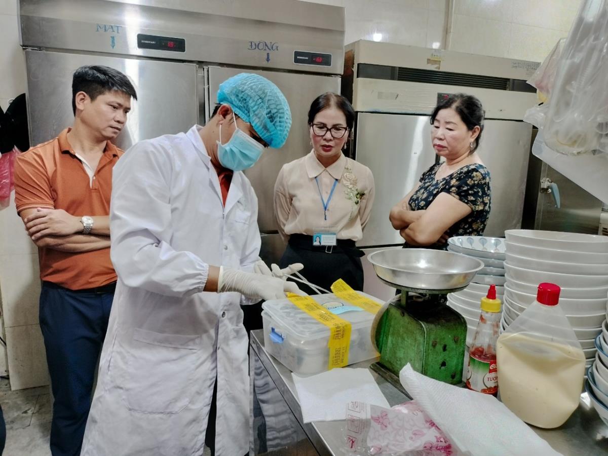 Đoàn công tác của Sở Y tế tỉnh Quảng Nam tiến hành lấy mẫu tại tiệm bánh mỳ Phượng đưa đi kiểm nghiệm. (Ảnh: Công an Đà Nẵng)