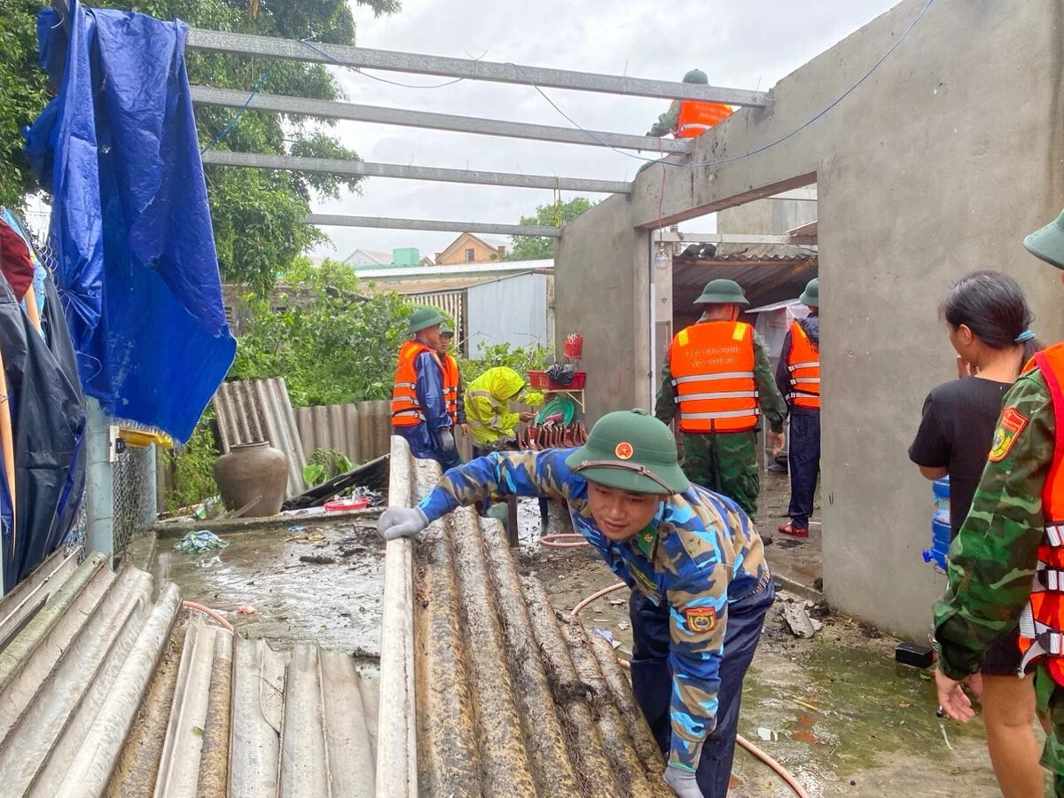 Lực lượng chức năng giúp người dân lợp lại mái nhà. (Ảnh: BĐBP tỉnh Thừa Thiên Huế)