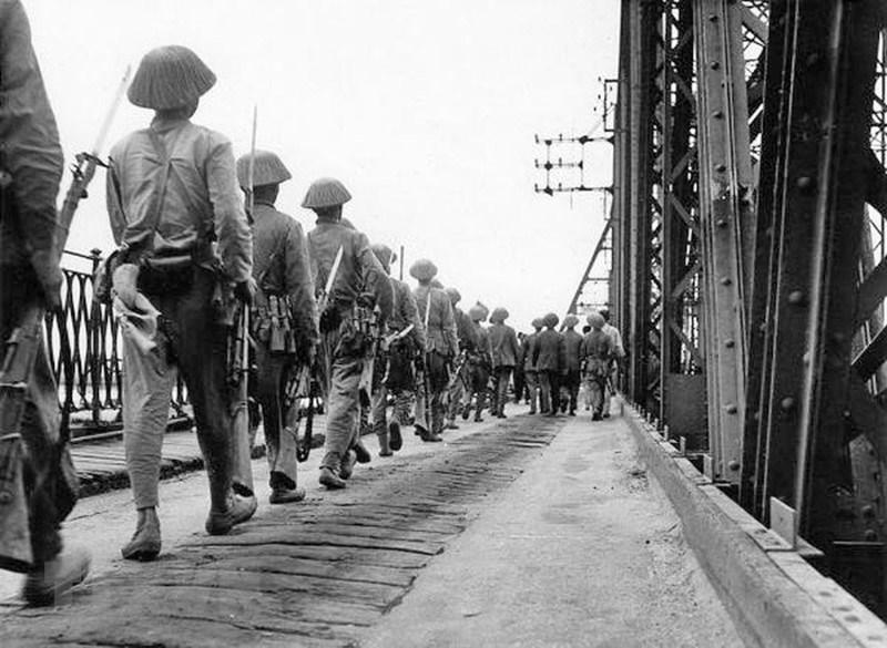 Quân đội ta qua cầu Long Biên vào tiếp quản thành phố, cùng lúc quân Pháp rút khỏi Hà Nội qua cây cầu này phía chiều bên kia, chiều 9/10/1954. (Ảnh: TTXVN).
