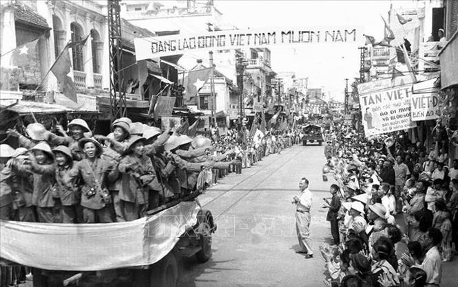 Đoàn xe chở các chiến sĩ Đại đoàn 308 tiến qua phố Hàng Đào trong niềm vui hân hoan của người dân Thủ đô. (Ảnh: TTXVN).