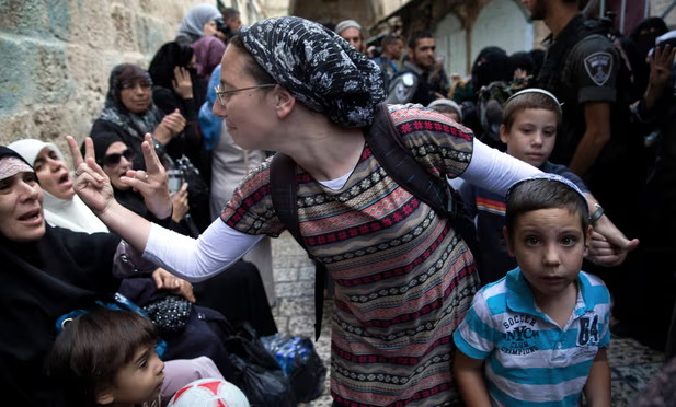 Một phụ nữ Israel và một phụ nữ Palestine ra hiệu cho nhau trong cuộc biểu tình ở Thành phố cổ Jerusalem. (Ảnh: Reuters)