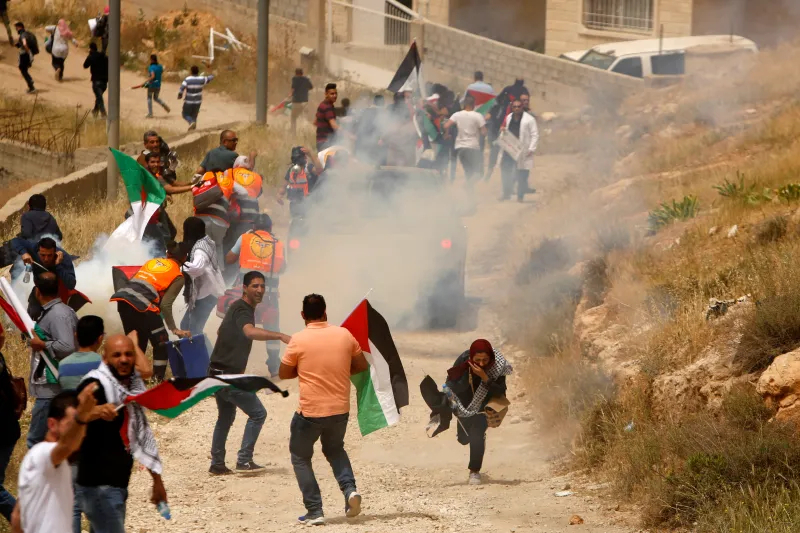 Người Palestine trốn thoát khỏi hơi cay do lực lượng an ninh Isaeli bắn. (Ảnh: Time)