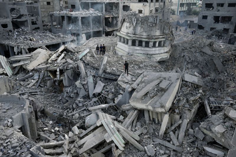 Người dân Palestine lục soát đống đổ nát tại nhà thờ Hồi giáo Yassin sau khi nơi này bị tấn công bởi cuộc không kích của Israel. (Ảnh: Adel Hana/AP)