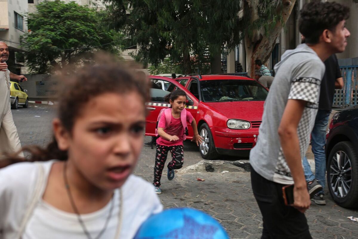 Trẻ em chạy trốn khi bom rơi gần Bệnh viện Al - Shifa (Gaza). (Ảnh: Samar Abu Elouf/The New York Times/Redux)