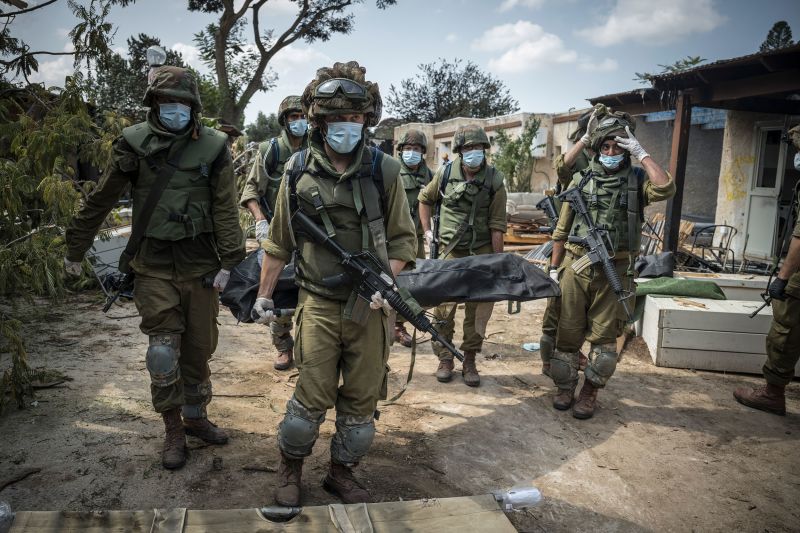 Các binh sĩ Israel khiêng thi thể các nạn nhân thiệt mạng trong cuộc xung đột. (Ảnh: Sergey Ponomarev/The New York Times/Redux)